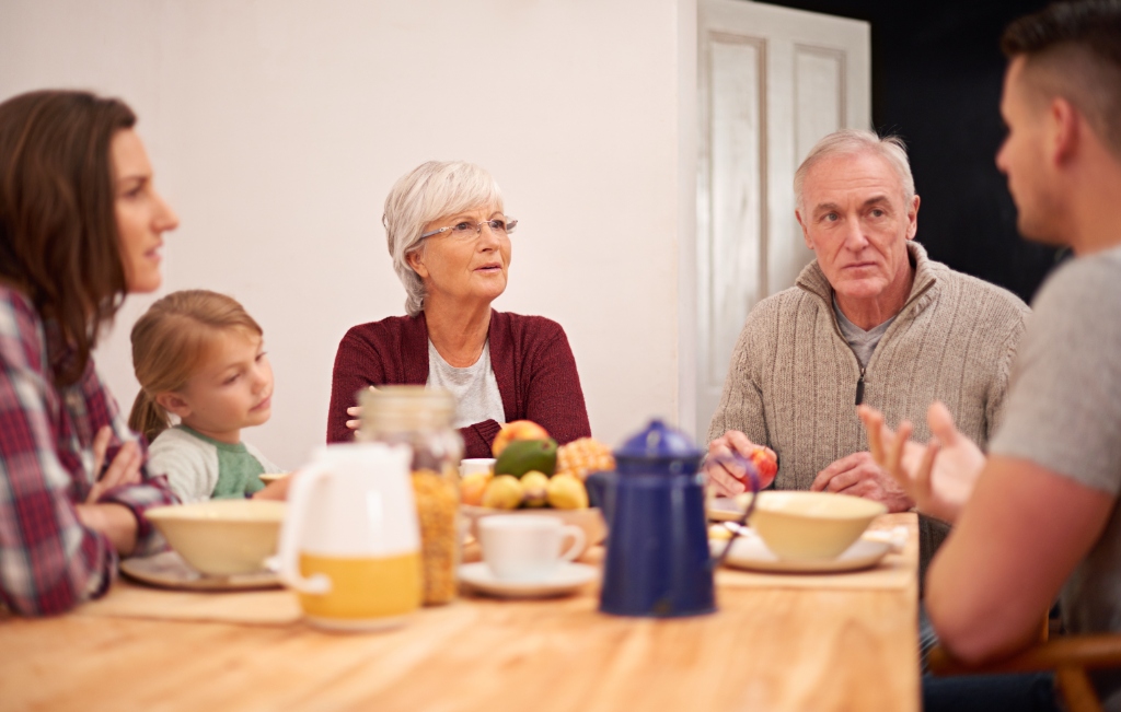 Família reunida à mesa conversando e compartilhando momentos